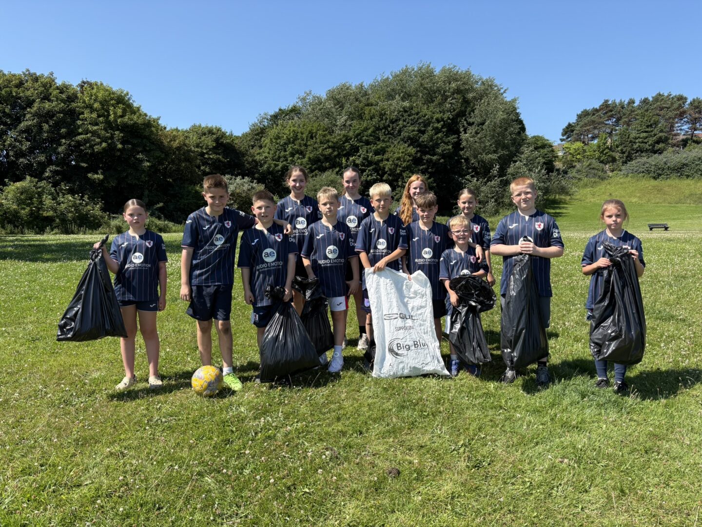 Twelve young volunteers from the Raith Rovers Community Foundation pose with sacks of litter collected during a beach clean at Pathhead Sands, Kirkcaldy.